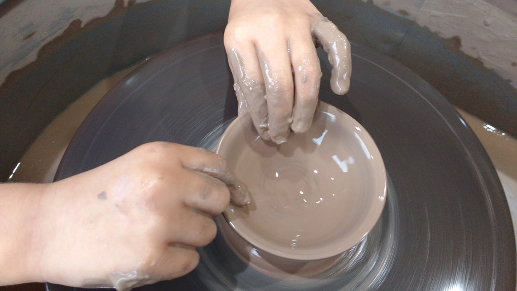 Little hands throwing pot